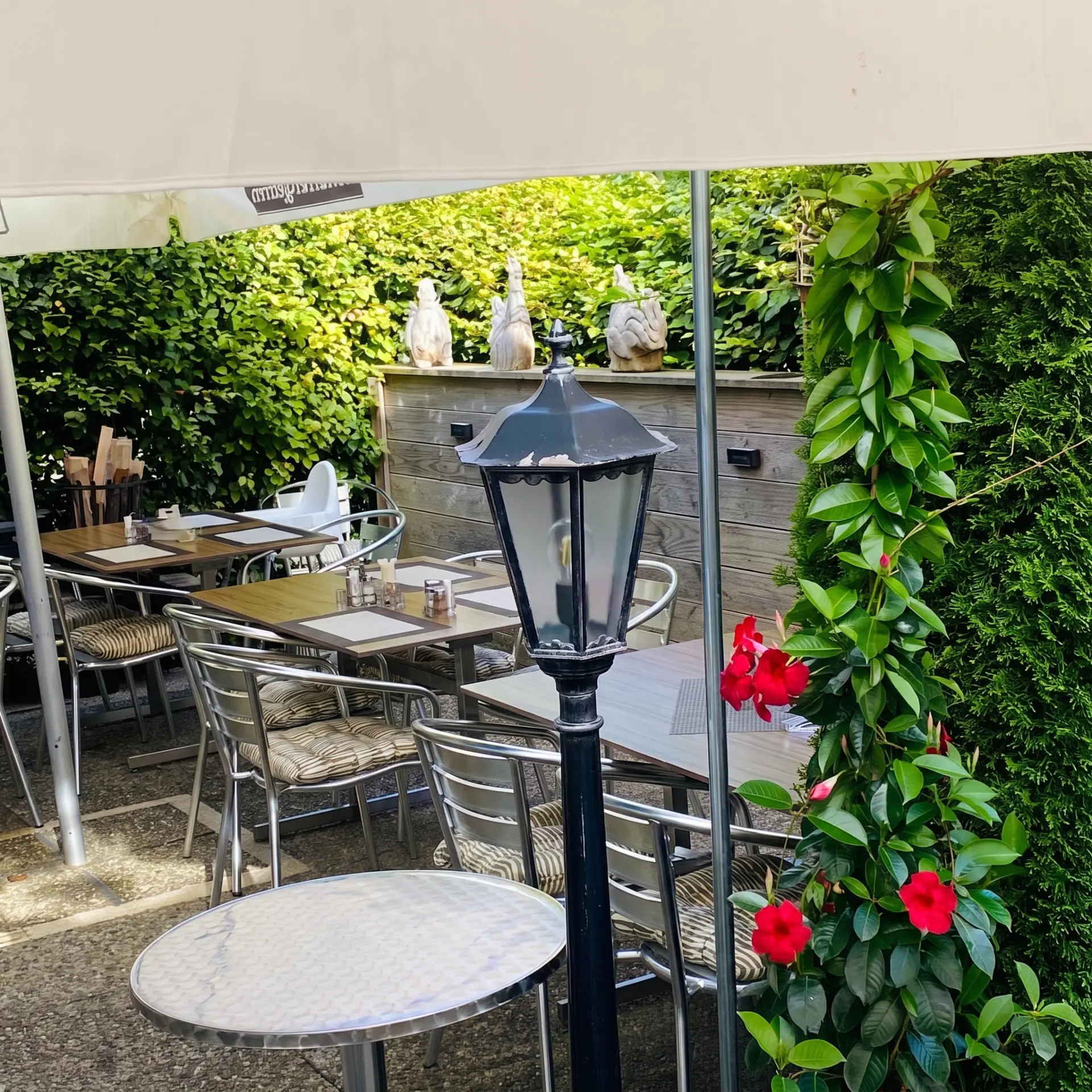 Schattige Sitzplätze mit Laterne im Garten der Traube